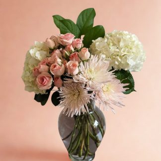 Champagne Garden floral arrangement with blush spray roses, cream hydrangeas, and pale spider mums in a clear glass vase