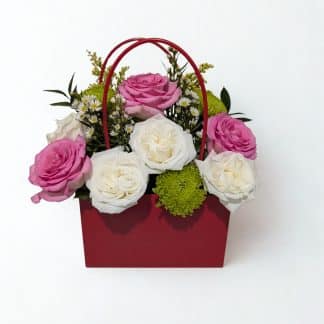 Pink roses, white garden roses, and green button mums arranged in a red handbag gift box — Irus Floral Design